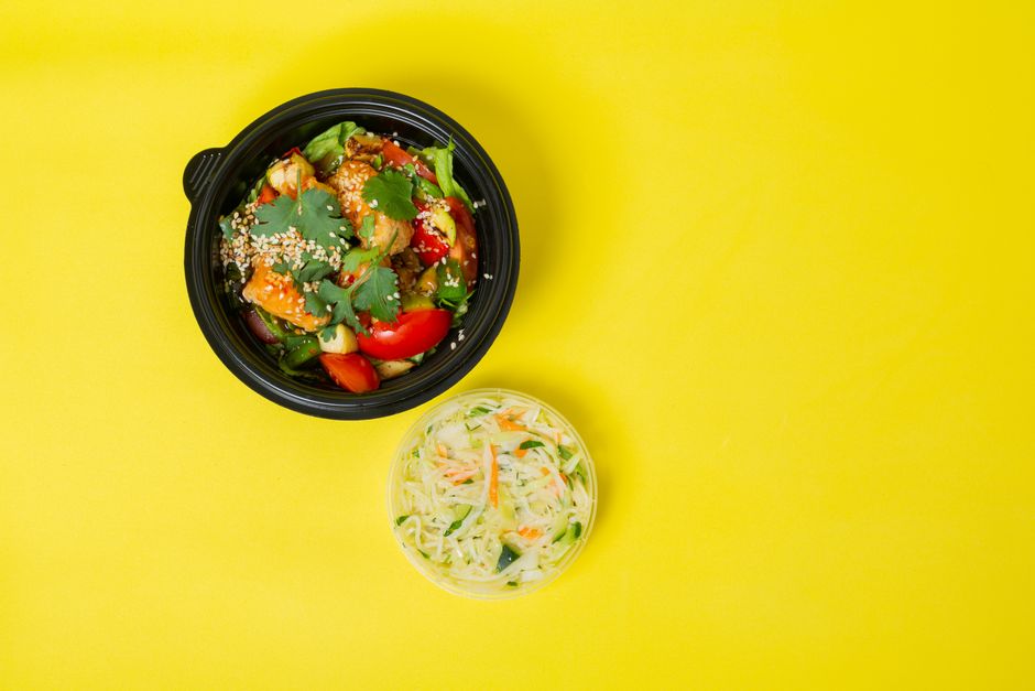 Colorful vegetable salad in a bowl with a yellow background for healthy eating concepts.